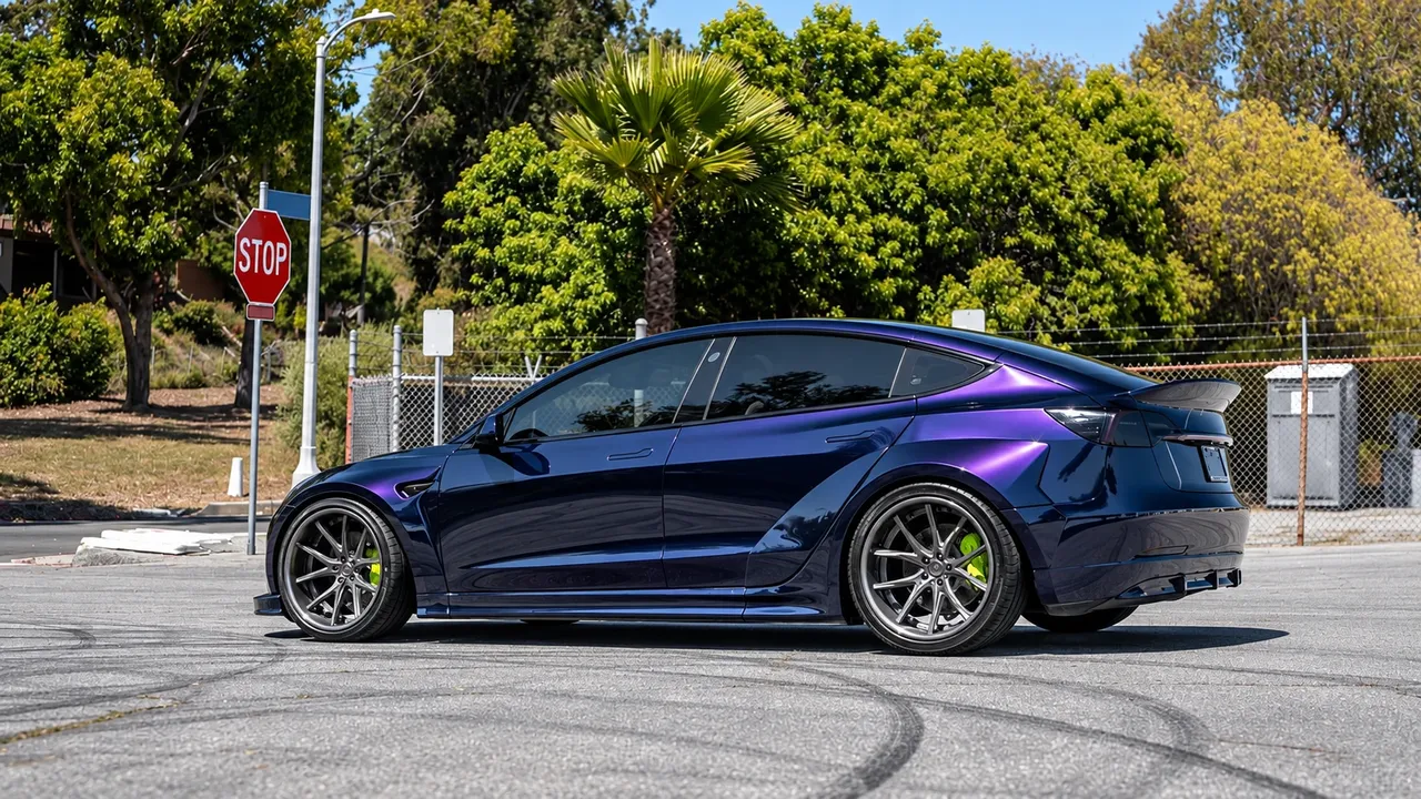 Tesla in a deep purple color-change wrap with dark wheels