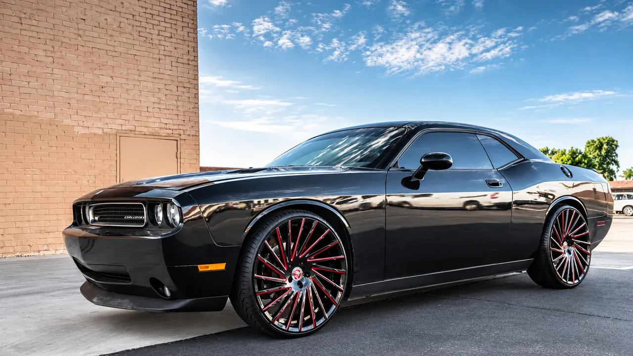 Black Dodge Challenger on large multi-spoke wheels with red accents