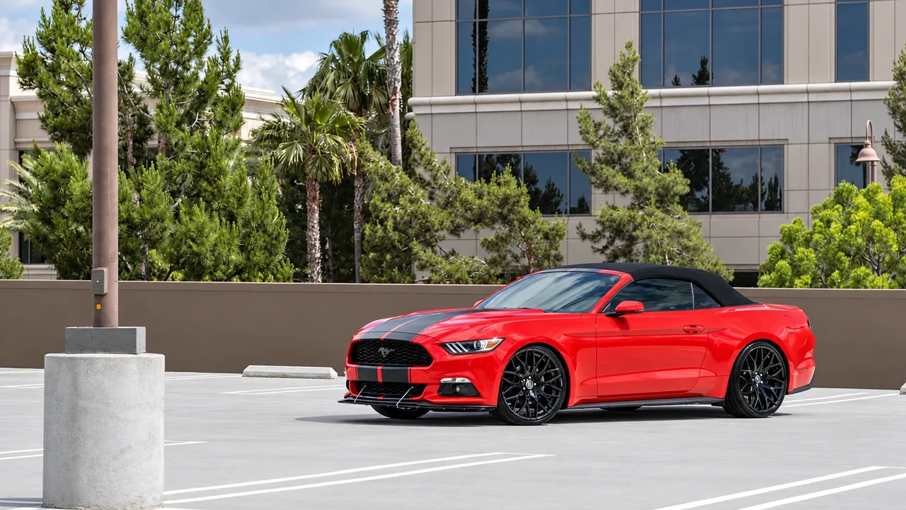 Red Ford Mustang convertible with black stripes on black wheels